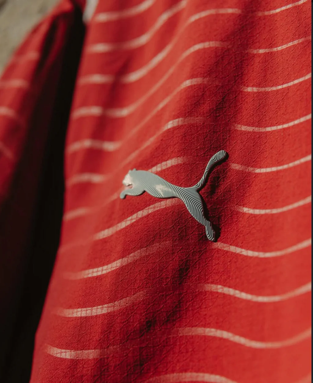 Detalhe logo Puma camisola vermelha